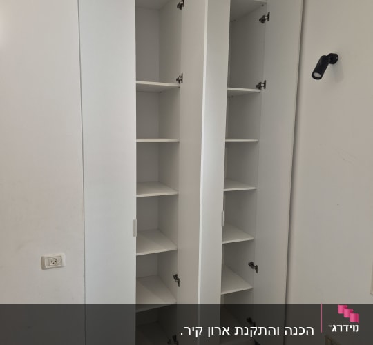 ארון לבן עם דלתות פתוחות ומדפים פנימיים
